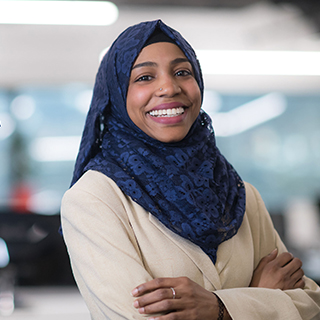 Black Muslim woman standing in an office