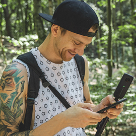 Young man in a forest looking at his cell phone